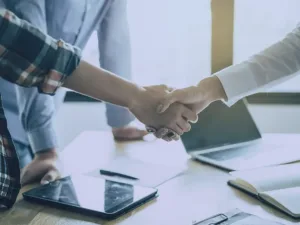 Equipe de vendas utilizando sistema ERP com gráficos de desempenho na tela