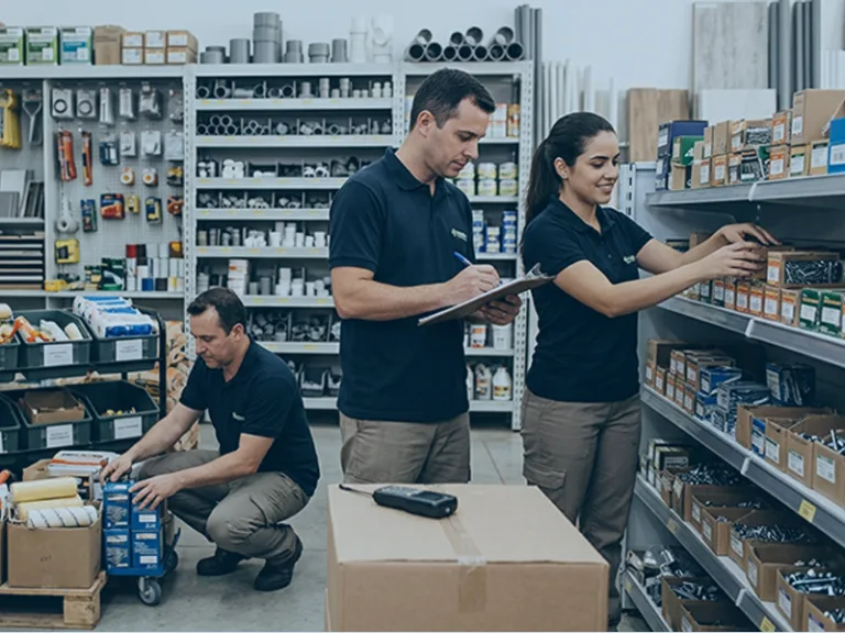 Equipe organizando reposição de estoque em loja de materiais de construção