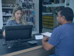 Gestor analisando vendas a prazo e contas a receber em loja de ferragens