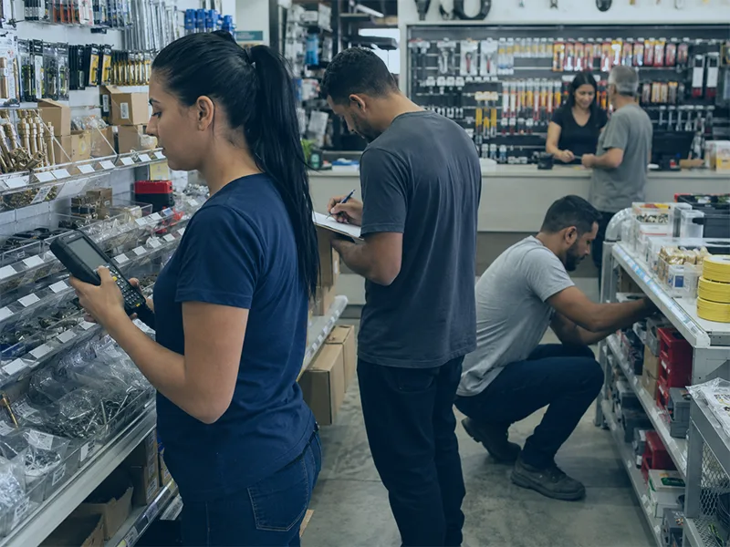 Equipe fazendo inventário em loja de ferragens organizada sem parar a operação