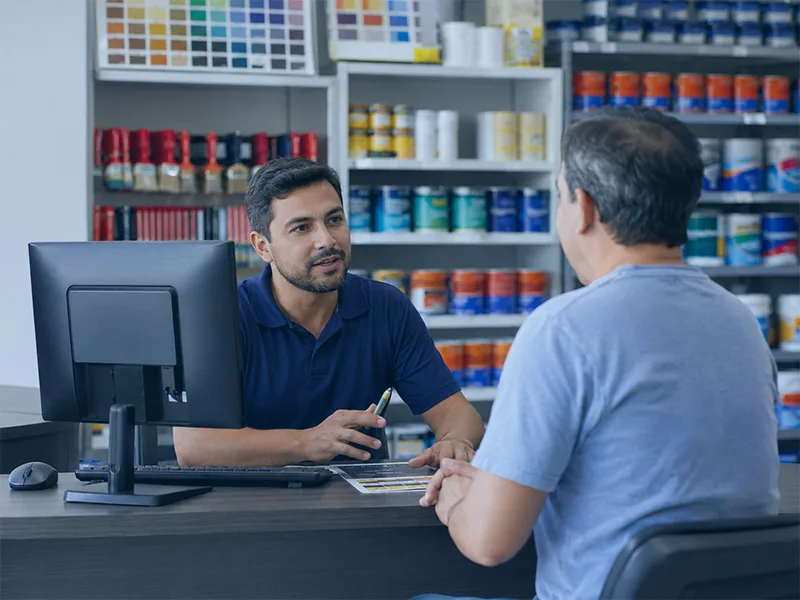 Vendedor de loja de tintas atendendo cliente